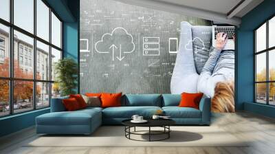 Cloud computing with man using a laptop in a modern gray chair Wall mural