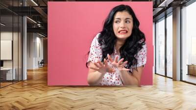 Disgusted face expression with young woman on a solid background Wall mural