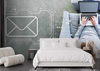 Email with man using a laptop in a modern gray chair Wall mural