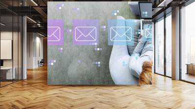 Emails with man using a laptop in a modern gray chair Wall mural