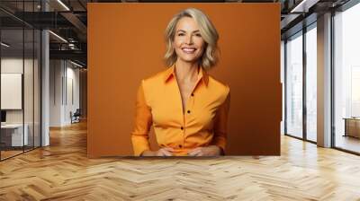 happy mature businesswoman on an orange solid background Wall mural