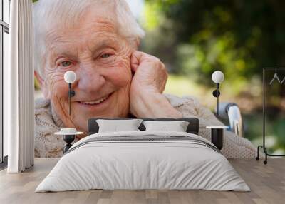 happy senior lady in wheelchair smiling outside Wall mural