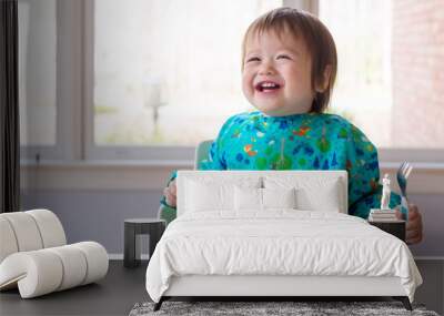 Happy toddler boy eating dinner in his highchair Wall mural