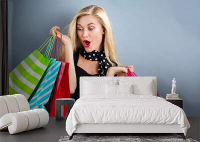 Happy young blonde woman with shopping bags Wall mural