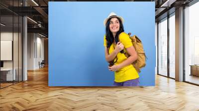 Happy young woman hiking on a blue background Wall mural