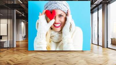 Happy young woman holding a heart cushion Wall mural