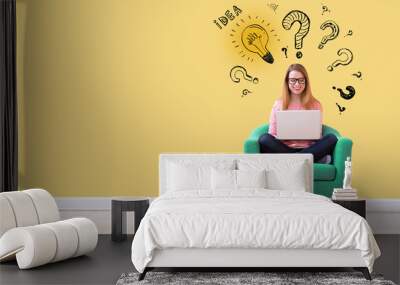 Idea light bulbs with question marks with young woman using her laptop in a chair Wall mural