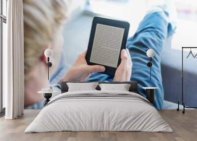 Man reading a book on digital device Wall mural