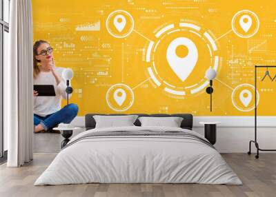 Map pin concept with young woman holding a tablet computer Wall mural