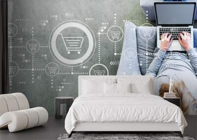 Online shopping theme with man using a laptop in a modern gray chair Wall mural