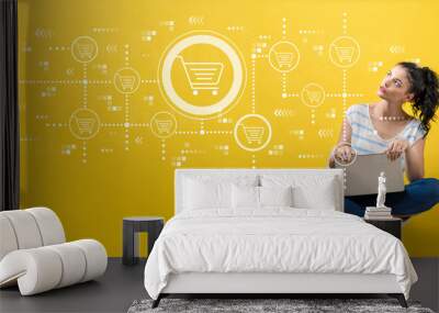 Online shopping theme with young woman using a laptop computer  Wall mural