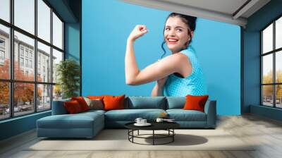 Powerful young woman in a success pose Wall mural