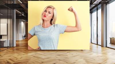 Powerful young woman on a yellow background Wall mural