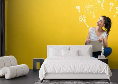 Question marks with woman using a laptop Wall mural