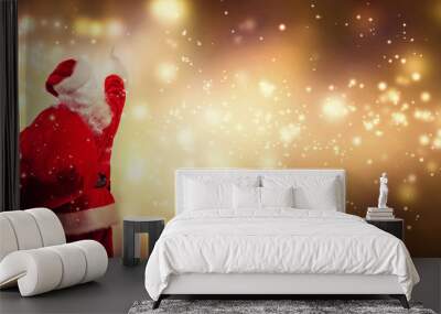 Santa pointing at the sky on a shiny light background Wall mural