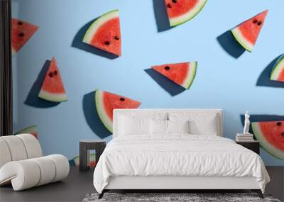 Sliced watermelons arranged on a blue background Wall mural