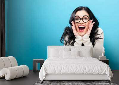 Surprised young woman posing on a solid background Wall mural