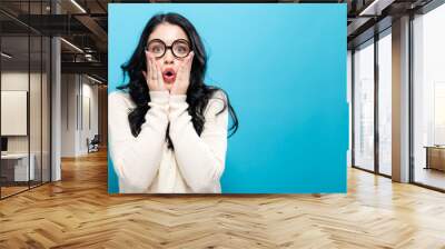 Surprised young woman posing on a solid background Wall mural