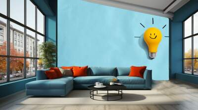 Yellow light bulb with happy face - flat lay Wall mural