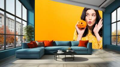 Young woman holding a pumpkin in halloween theme Wall mural