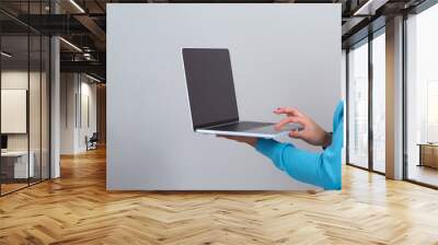 Young woman with a laptop computer on a gray background Wall mural