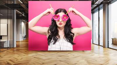 Young woman with flowers on a pink background Wall mural