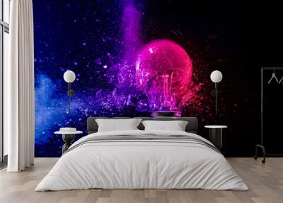 Pink light bulb exploding in colorful powder on black background Wall mural