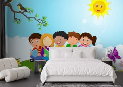 Happy children sitting on the grass while reading books Wall mural