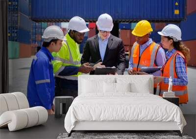 Group of multiracial workers in safety uniforms and hardhats work at logistics terminal dock with stacks of containers, loading control, and management shipping goods, cargo transportation industry. Wall mural