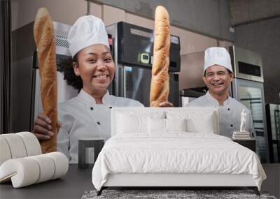 Portrait of professional chefs in white hat uniforms looking at camera with a cheerful smile and proud with Baguette in kitchen. A friend and partner of bakery foods and fresh daily bakery occupation. Wall mural