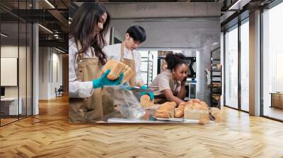 Three young friends and startup partners of bread dough and pastry foods busy with homemade baking jobs while cooking orders online, packing, and delivering on bakery shop, small business entrepreneur Wall mural