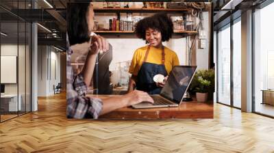 Two cafe business startup partners and friends, African American female, and Thai male baristas talk and cheerful smile together at counter bar of coffee shop, happy service job, and SME entrepreneur. Wall mural