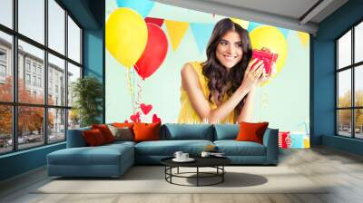 Beautiful woman holding a present at her birthday party Wall mural