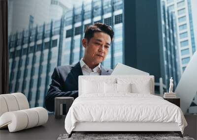 Business man using tablet in city outdoor with office buildings in the background stock photo Wall mural