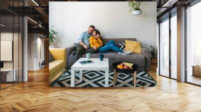 Embraced couple relaxing together on their sofa at living room in home.
Happy couple having romantic moment on couch Wall mural