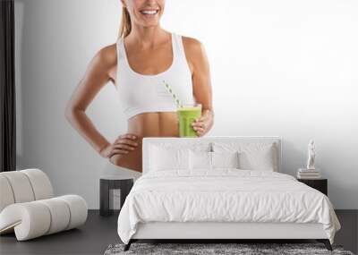 fit, beautiful, young woman holding a healthy, green smoothie, isolated on white background Wall mural