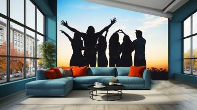 Group of people jumping outdoors; sunset  Wall mural