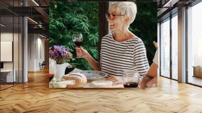 Senior woman with a glass of wine   Wall mural