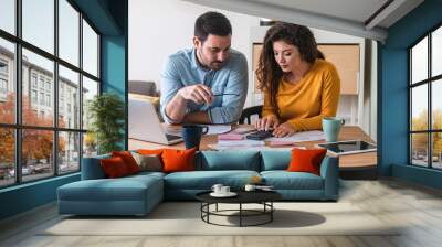 Young couple calculating their domestic bills at home stock photo Wall mural