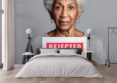 An older African woman holding a paper with words Rejected, Too Old. Generative AI ageism protest illustration. Wall mural