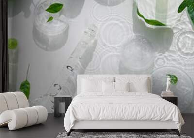 Cosmetic skincare background. Herbal medicine with green leaves. Natural sunlight, long shadows. Splashes of water, splashes. Chemical glassware, petri dishes, vials. Natural skincare background. Wall mural