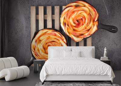 Homemade puff pastry with rose shaped apple slices baked in iron skillets on dark Wall mural