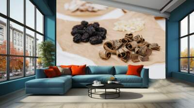 Collection of raw Chinese herbal medicine including magnolia bark, black dates, and almond pits Wall mural