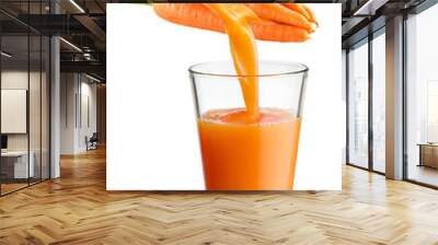 Fresh juice pours from carrot into the glass isolated on white background. Wall mural