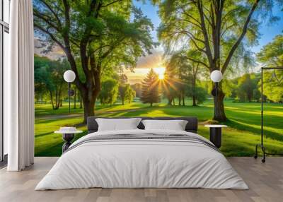 Sun shining through trees on lush green golf course Wall mural