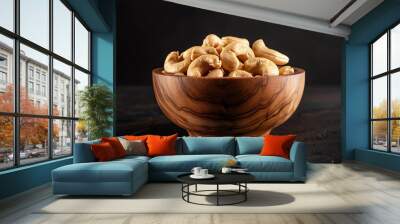 Wooden bowl filled with delicious cashew nuts on a dark background. Perfect for healthy snacks and cooking ingredients. Wall mural