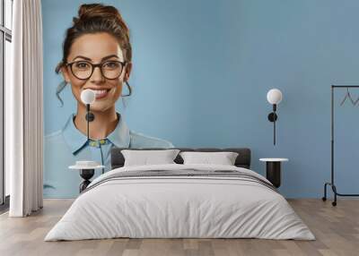 Attractive  female model wearing eyeglasses and shirt on pastel blue background. Wall mural