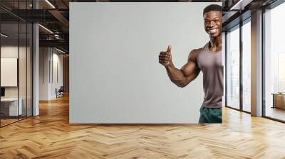 Handsome fit, athletic young man showing his muscles isolated on solid color background. Wall mural