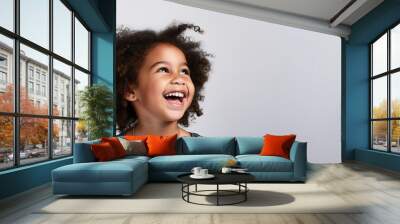 Radiant Joy: Carefree Laughing Child in Isolation on White Background Wall mural