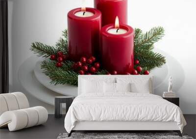 A festive centerpiece featuring three red candles surrounded by evergreen branches and red berries on a white plate. Wall mural